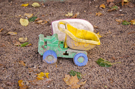 秋季沙箱中废弃的塑料卡车玩具