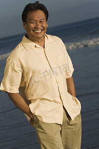 海滩上一个双手插在口袋里的快乐男人的肖像