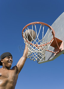 年轻赤裸上身的非洲裔美国人在篮下扣篮