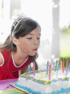 一个年轻女孩吹灭生日蜡烛的特写