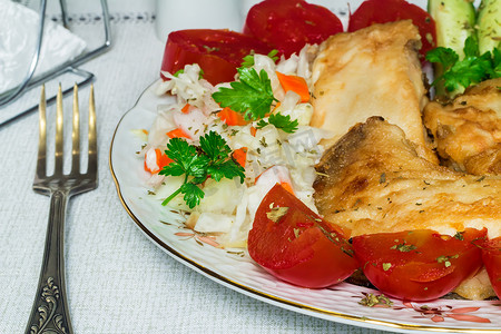 烤鱼和蔬菜放在盘子里。