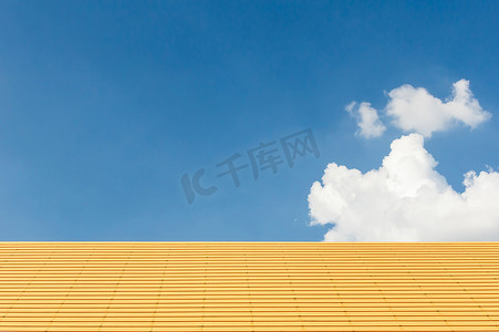 黄色屋顶有晴朗的天空和云彩在背景中。