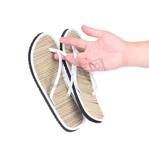 3d二字立体摄影照片_手里拿着一双条纹人字拖凉鞋。
