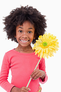 一个微笑的女孩拿着一朵花的肖像