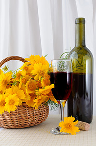白酒psd摄影照片_一瓶玫瑰酒，配有玻璃杯和篮子里的黄色花朵