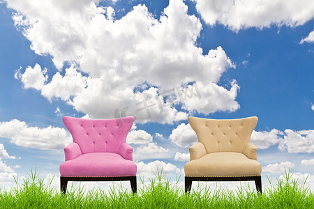 奶油色沙发摄影照片_蓝天绿草上的粉色和奶油色沙发