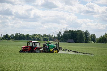 夏季拖拉机喷洒绿色农田