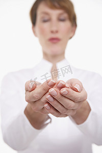 手托起的硬币摄影照片_一个模糊的女人在白色背景下双手托起的特写