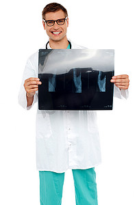 教育专家摄影照片_快乐的年轻外科医生展示病人的 X 光片