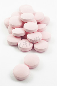 粉红色的药片和药丸隔离在白色