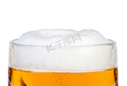 啤酒拍摄摄影照片_啤酒杯的上部和泡沫特写。
