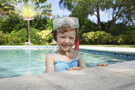 游泳池里戴着潜水面罩和通气管的可爱小女孩的肖像