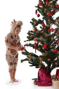 穿着长颈鹿服装的男孩在圣诞树附近