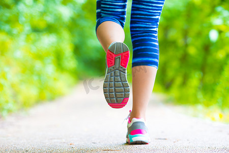 行走在路上摄影照片_运动员跑步女脚在路上跑步的鞋子特写