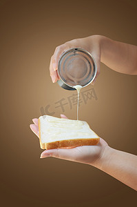 手拿着炼乳罐和面包