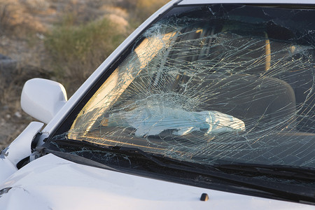 砸碎玻璃摄影照片_沙漠高速公路上被砸碎的汽车挡风玻璃的特写