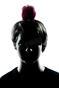 易经头像摄影照片_一个年轻的少年男孩或女孩剪影，他的头上有一个苹果