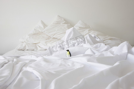 小企鹅摄影照片_家里凌乱的床上玩具企鹅的景色
