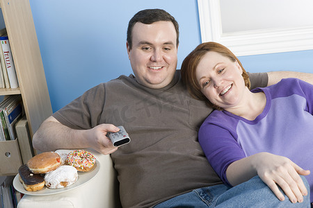 快乐的肥胖夫妇在家看电视