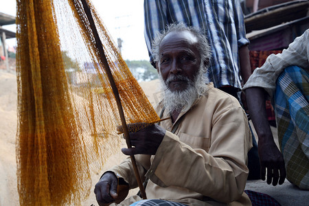 西孟加拉邦库姆罗哈利，一名渔民在下次捕鱼前编织渔网的肖像