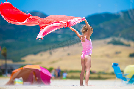 有沙滩毛巾的小女孩在热带假期期间