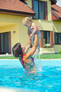 孩子游泳摄影照片_女孩和母亲在泳池里