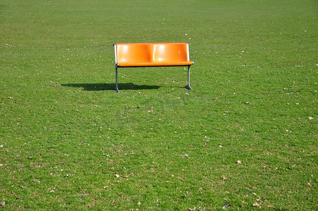 螺距摄影照片_草坪上的橙色长凳