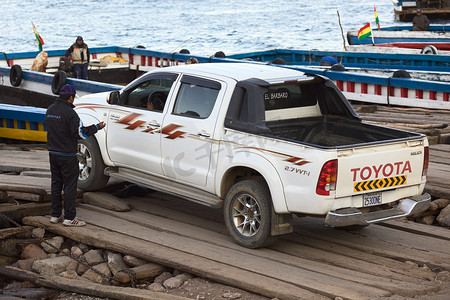 皮卡车摄影照片_皮卡车驶上玻利维亚的喀喀湖提奎纳的渡轮
