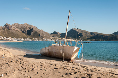 海蓝之谜logo摄影照片_暴风雨后小船搁浅在海滩上
