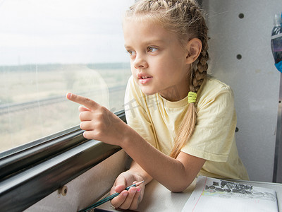 二等奖等奖摄影照片_女孩在火车二等车厢的窗户里露出一根手指