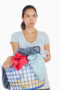 衣服混洗摄影照片_愤怒的女人拿着装满衣服的篮子