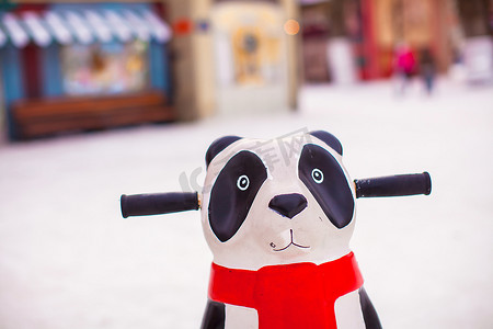 活泼小企鹅摄影照片_熊猫帮助小滑冰者教冰上滑冰