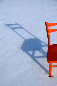 雪地上的橙色椅子阴影