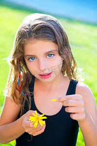 儿童女孩用黄色雏菊花瓣测试爱情