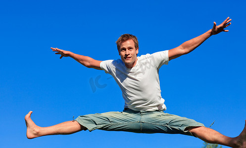 一个可爱的男人在户外空中跳跃的肖像