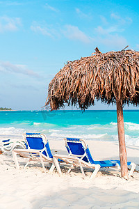 白色沙滩上的海滩日光浴床和遮阳伞