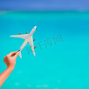 绿松石海女手背景中的小白色飞机模型
