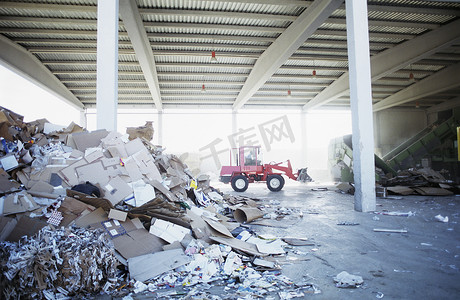 废品厂摄影照片_回收厂后台有挖掘机卡车的废纸堆