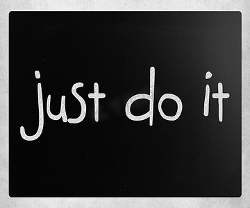 手写短语摄影照片_黑板上用白色粉笔手写“Just Do It”