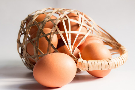 鸡蛋在白色背景的篮子柳条中，鸭蛋在篮子里。