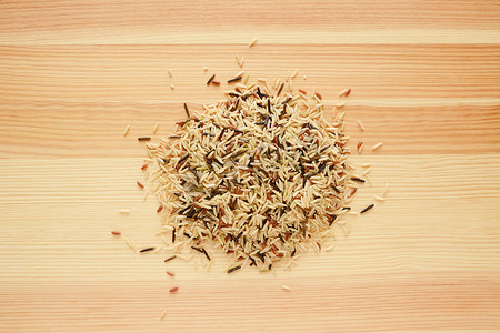 格木纹摄影照片_木头上的野生稻、棕色印度香米和红色卡马格谷物