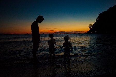 菲律宾长滩岛海滩夕阳下的父女剪影