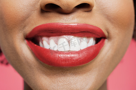 一位非洲裔美国女性在彩色背景中微笑的特写细节