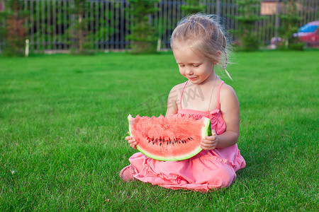 手里拿着一块西瓜的可爱有趣的小女孩