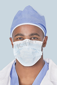 浅蓝色背景中戴着面具的男外科医生的特写