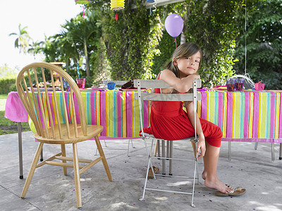 生日摄影照片_生日聚会后坐在桌边的小女孩的肖像