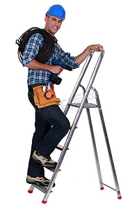 一名电工正在爬梯子。