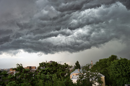 灰色暴风摄影照片_城市上空的暴风雨云