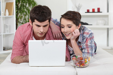 年轻夫妇在笔记本电脑上看电影