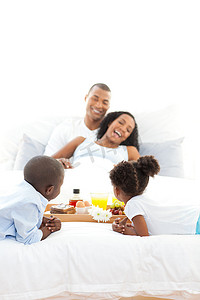 快乐的家庭在卧室吃早餐